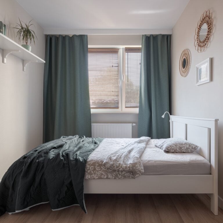 Comfortable guest room with big bed, window with curtains and stylish decorations